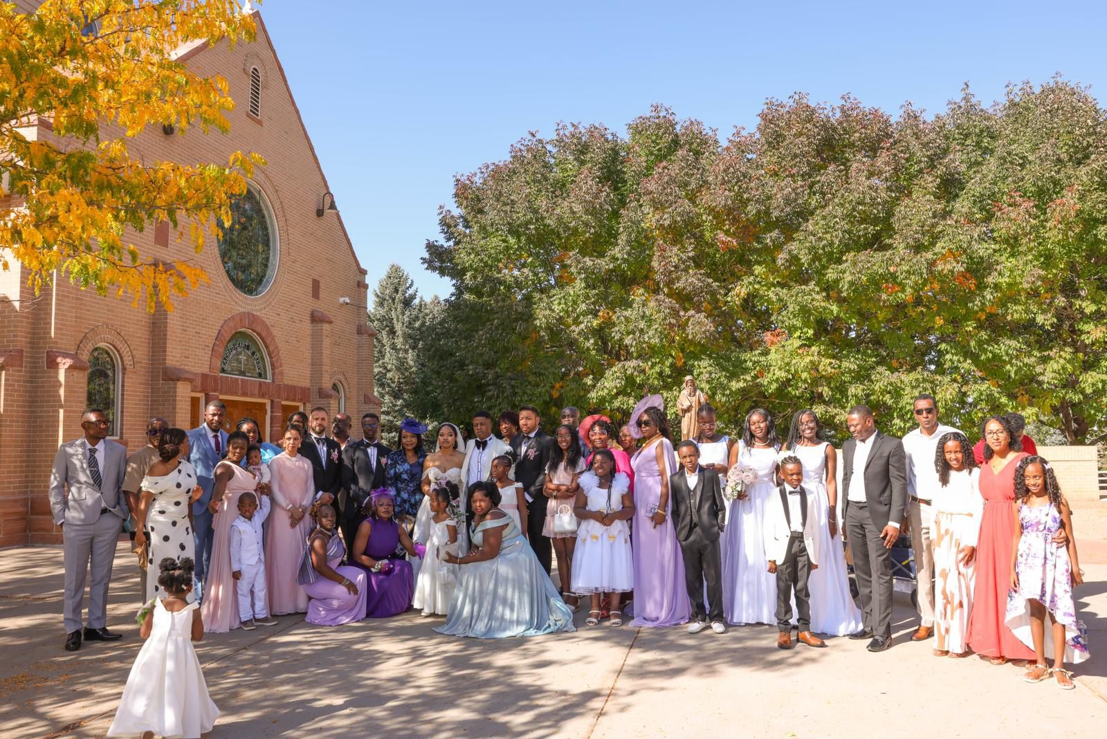 Large wedding group portrait outside the church on an autumn day