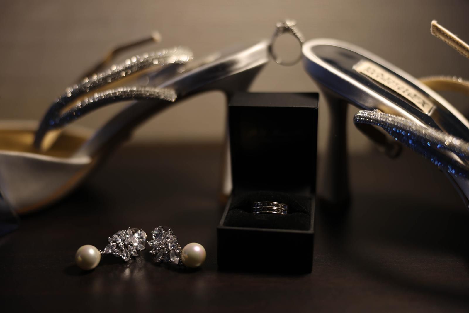 Wedding rings, pearl earrings and bridal heels detail shot