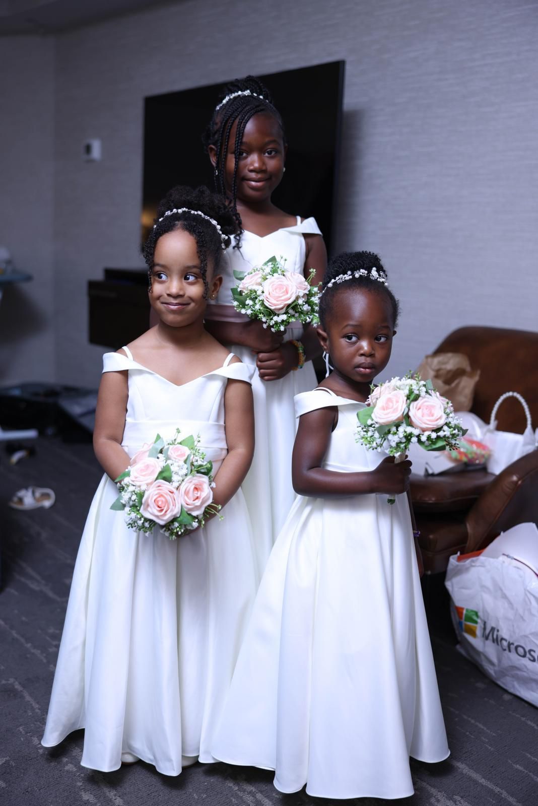 Three flower girls holding blush rose bouquets