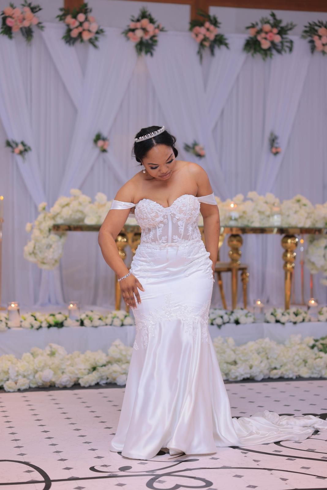 Bride in a satin gown on a monogrammed ballroom dance floor